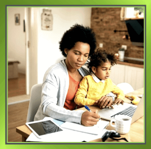 image of lady working at home with a child on her knee to show Supporting Working Parents During School Holidays